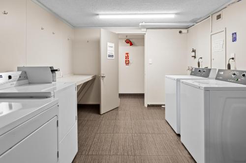 a bathroom with white counters and white cabinets at Imperial Hotel Rotorua in Rotorua