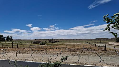 a barbed wire fence in the middle of a field at Karoo Uitsig Guesthouse in Hanover
