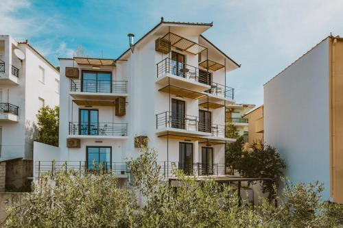 an image of a white building with balconies at Viento Luxury Apartments in Plomarion