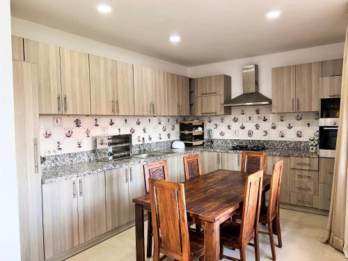 马拉喀什Villa Zeen Garden的配有木桌和椅子的厨房