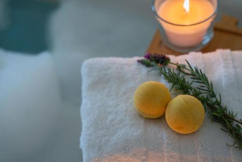 two oranges on a napkin with a candle and a candle at Viento Luxury Apartments in Plomarion