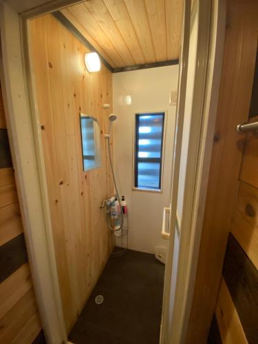 a hallway leading to a bathroom with a shower at hareruya tsugaike in Chikuni