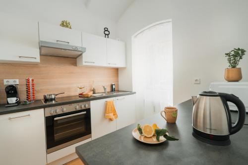a kitchen with white cabinets and a tea kettle on a counter at NOOR - Golden Mood or Cinema Luxe in Graz