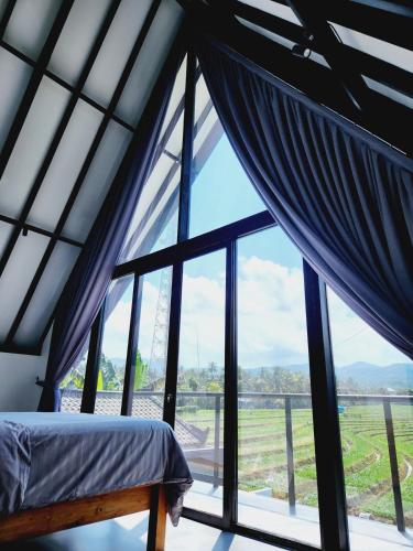 a bedroom with a bed and a large window at Villa cecile in Balian