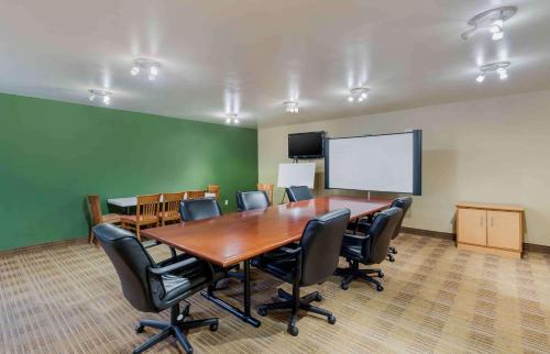 a conference room with a table and chairs and a screen at Extended Stay America Suites - Fayetteville - Fort Bragg in Fayetteville