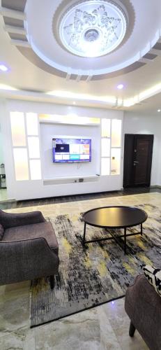 a living room with a couch and a table and a tv at TUT's Place in Sabo Kukwaba
