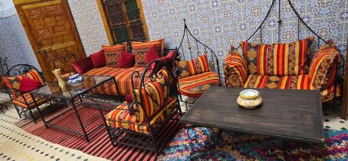 ein Wohnzimmer mit Sofas und einem Tisch in der Unterkunft Riad Raffaa in Marrakesch
