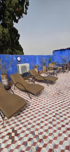 una fila di sedie a sdraio e tavolini su un pavimento piastrellato di Riad Raffaa a Marrakech