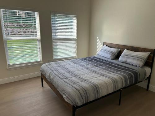 a bed in a bedroom with two windows at New 2025 Modern 3BR Retreat in Canyon Lake