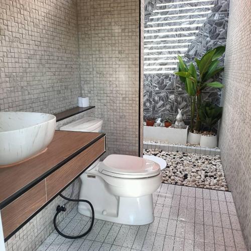 a bathroom with a white toilet and a sink at เดอรำพึง De Ramphueng ชายหาดแม่รำพึง ระยอง in Ban Chak Phai