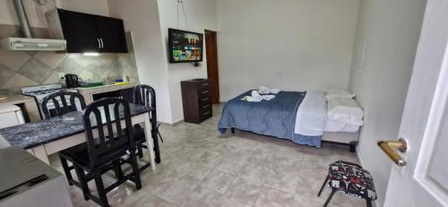 a bedroom with a bed and a kitchen with chairs at Rincon Austral in Ushuaia