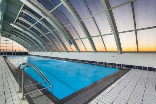 una grande piscina con soffitto in vetro di Luxury Darling Harbour Views, Pool & Parking a Sydney