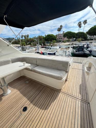 un canapé assis sur le pont d'un bateau dans l'établissement yacht 17M Princess V52 Cannes port canto 3 chambres AC, à Cannes