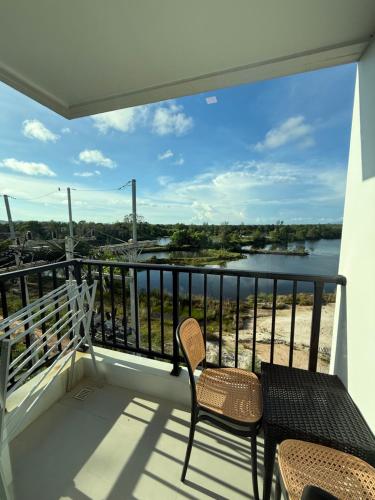 a balcony with two chairs and a view of a river at BEACH Condo Mae Phim in Ban Tha Fat
