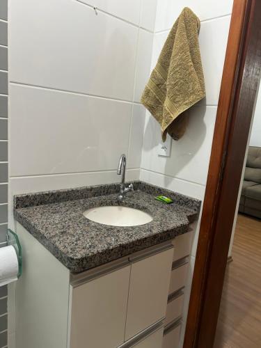a bathroom counter with a sink in a room at Confortável Apartamento em Condomínio in Pouso Alegre