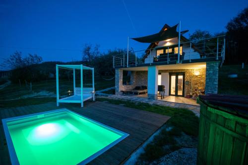 a villa with a swimming pool in front of a house at Káli Vineyard Estate in Köveskál