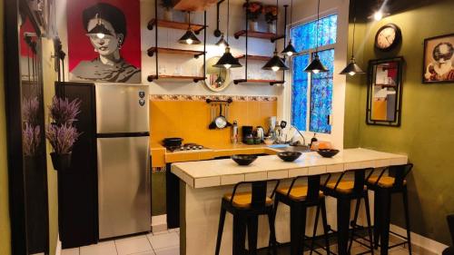 a kitchen with a refrigerator and some bar stools at Frida Downtown Apart in Playa del Carmen