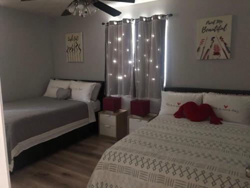 a bedroom with two beds and a window with lights at Nice house 10 minutes away to Disneyland or Knotts in Fullerton
