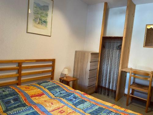 une chambre avec un lit, une commode et une chaise dans l'établissement Duplex 4 pièces, 6 pers, terrasse, Valloire - FR-1-263-282, à Valloire