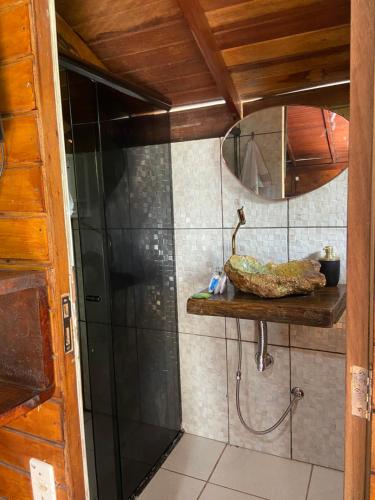 a bathroom with a shower with a mirror and a shelf at Chalé lawill ilha do mel in Paranaguá