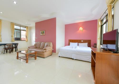 a hotel room with a bed and a couch and a tv at Sun and beach hotel in Pattaya South