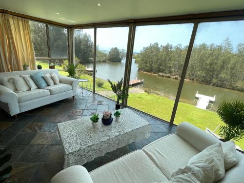 a living room with couches and a view of a lake at BasinWaterStays Waterfront Jetty - Brm1 Private Bedroom - Private Bathroom in Brm1 room - Shared Facilities - see Profile & Photos in Basin View