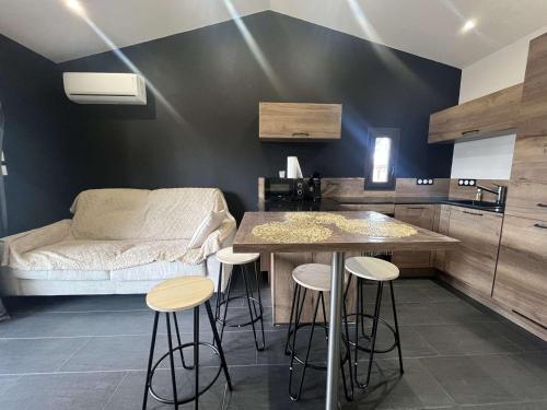 une cuisine avec une table et des tabourets dans une pièce dans l'établissement Appartement T2 avec piscine et parking, Cap d'Agde - FR-1-249-430, au Cap d'Agde
