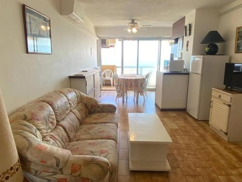 un salon avec un canapé et une cuisine avec une table dans l'établissement Grand 3 pièces climatisé avec parking à Canet-en-Roussillon - FR-1-833-2, à Canet