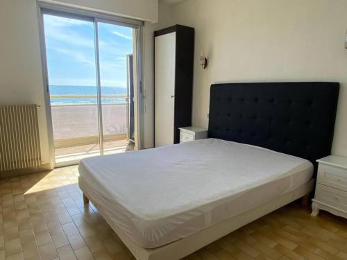 une chambre avec un grand lit et une grande fenêtre dans l'établissement Grand 2 pièces avec terrasse face à la mer à Canet-en-Roussillon - FR-1-833-1, à Canet