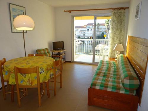 un salon avec une table à manger et un balcon dans l'établissement Appartement vue sur port avec parking et animaux admis - FR-1-833-6, à Canet