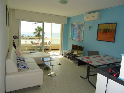 - un salon avec un canapé blanc et une vue sur la plage dans l'établissement Appartement Climatisé, 2 Chambres, Face Mer - FR-1-833-13, à Canet