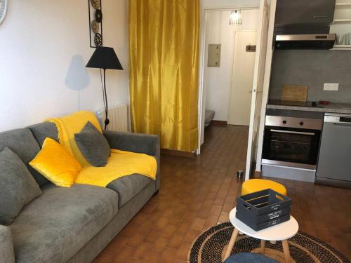 un salon avec un canapé et une cuisine dans l'établissement Studio Cosy avec Balcon, Animaux Acceptés, 4 Pers. - FR-1-833-22, à Canet