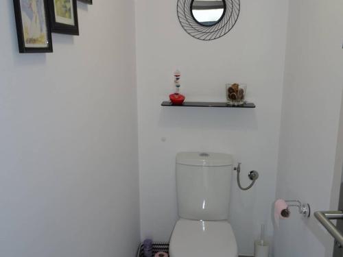 La salle de bains blanche est pourvue de toilettes et d'un miroir. dans l'établissement T4 Proche Plage avec Garage, Climatisation - FR-1-833-14, à Canet