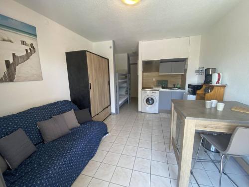 un salon avec un canapé bleu et une cuisine dans l'établissement Studio avec Terrasse et Parking à Canet-en-Roussillon - FR-1-833-9, à Canet