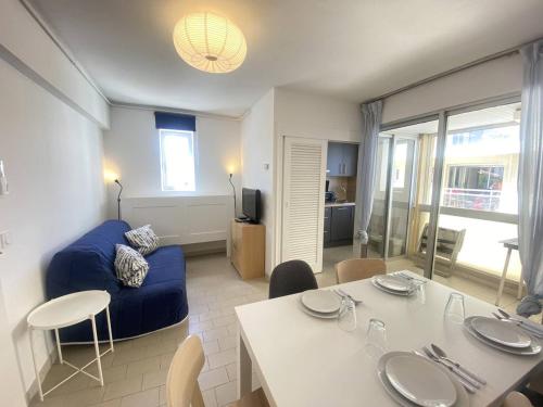 un salon avec un canapé bleu et une table dans l'établissement Appartement 2 pièces climatisé avec WIFI près de la plage - FR-1-833-16, à Canet