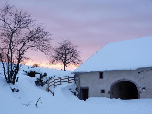 a barn covered in snow with a fence and trees at Gîte Vosges : nature, cheminée, animaux acceptés - FR-1-583-379 in Corravillers