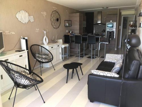 un salon avec un canapé et des chaises et une cuisine dans l'établissement Magnifique T3 Climatisé avec Parking Canet-en-Roussillon - FR-1-833-10, à Canet