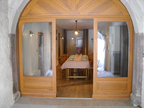 a dining room with a table through a glass door at Gîte Vosges : nature, cheminée, animaux acceptés - FR-1-583-379 in Corravillers