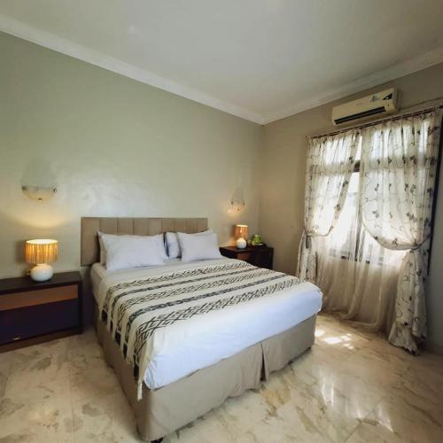 a bedroom with a large white bed and curtains at Deva Bali Villa in Kerobokan