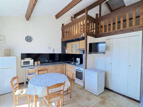 - une cuisine avec une table, une table et des chaises dans l'établissement Charmante maison mitoyenne à Biscarrosse Plage, proche de la mer pour des vacances en famille - FR-1-831-9, à Biscarrosse