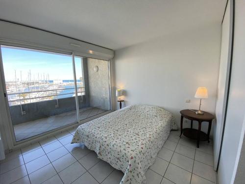 une chambre avec un lit et une grande fenêtre dans l'établissement Grand appartement 3 pièces avec terrasse et parking à Canet-en-Roussillon - FR-1-833-27, à Canet