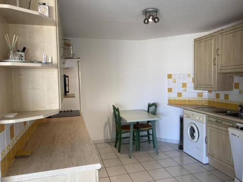 - une cuisine avec une table, une petite table et des chaises dans l'établissement Grand appartement 3 pièces avec terrasse et parking à Canet-en-Roussillon - FR-1-833-27, à Canet