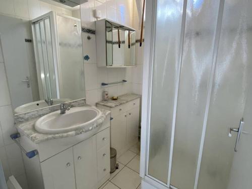 une salle de bain blanche avec un lavabo et une douche dans l'établissement Grand appartement 3 pièces avec terrasse et parking à Canet-en-Roussillon - FR-1-833-27, à Canet
