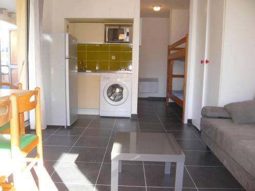 un salon avec un canapé et une machine à laver dans l'établissement Studio Cabine avec Terrasse Spacieuse à 300m de la Plage - FR-1-833-28, à Canet
