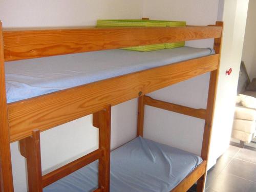 - un lit superposé avec des draps bleus sur la étagère inférieure dans l'établissement Studio Cabine avec Terrasse Spacieuse à 300m de la Plage - FR-1-833-28, à Canet
