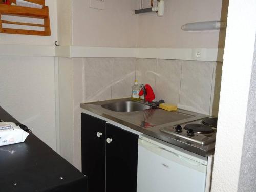 une petite cuisine avec un évier et une cuisinière dans l'établissement Studio avec Parking - C 033 - FR-1-833-29, à Canet