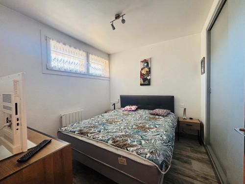 - une chambre avec un lit et un bureau avec un clavier dans l'établissement Saint Cyprien : T2 rénové avec Loggia & Parking privatif - FR-1-309-506, à Saint-Cyprien