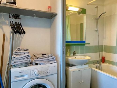 une salle de bain avec une machine à laver et un lavabo dans l'établissement Appartement 2 pièces avec piscine - FR-1-748-30, à Canet