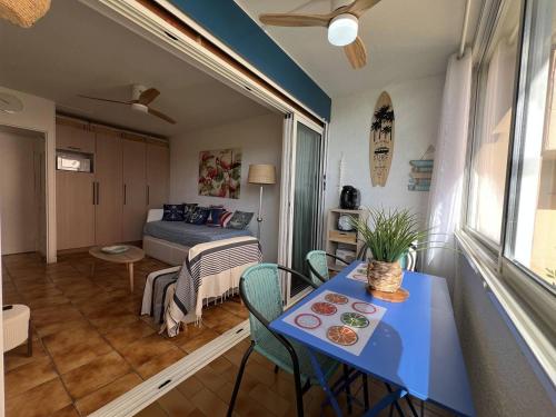 Cette petite chambre comprend une table bleue et un lit. dans l'établissement Appartement 2 pièces avec Parking - 4 personnes, Port Leucate - FR-1-81-637, à Port-Leucate