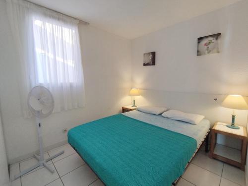 - une chambre avec un lit vert et un ventilateur dans l'établissement Villa T3 Mezzanine - Parking Privé - À 6 min de la plage - 6 pers. - Narbonne-Plage - FR-1-795-62, à Narbonne